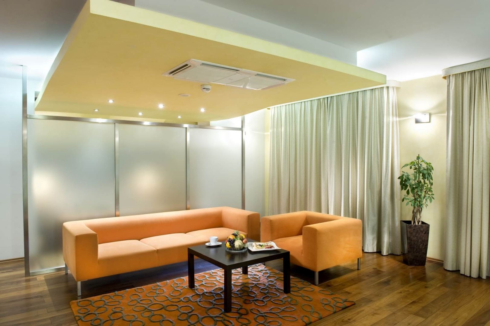 stylish hotel apartment in Žilina with orange sofa and table.