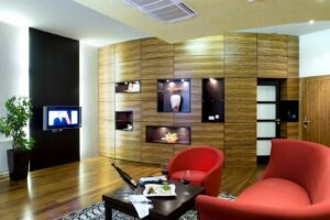 spacious apartment in the hotel in Žilina with red sofa and TV.